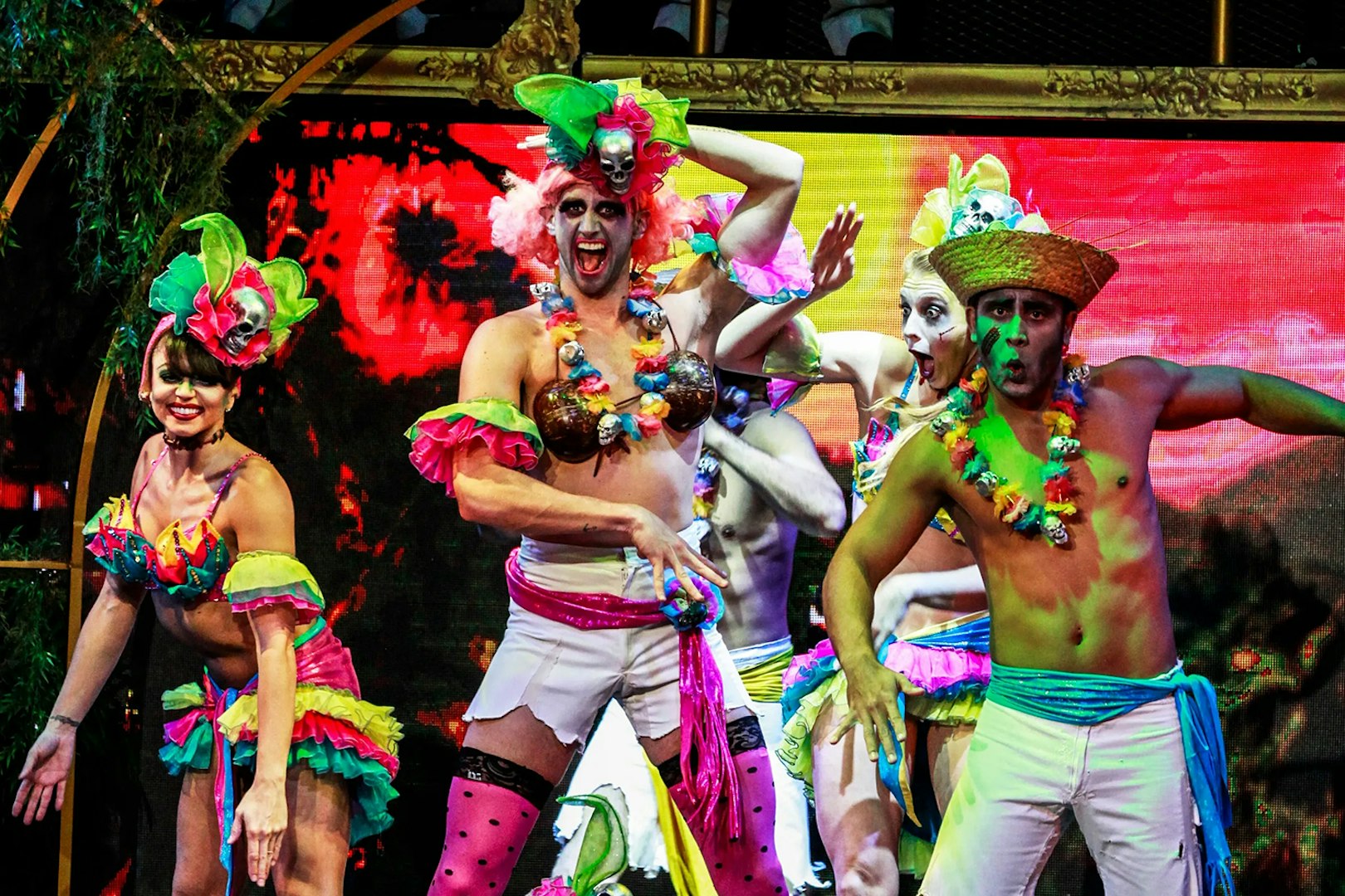 Performers in colorful costumes on stage during Zombie Burlesque show.