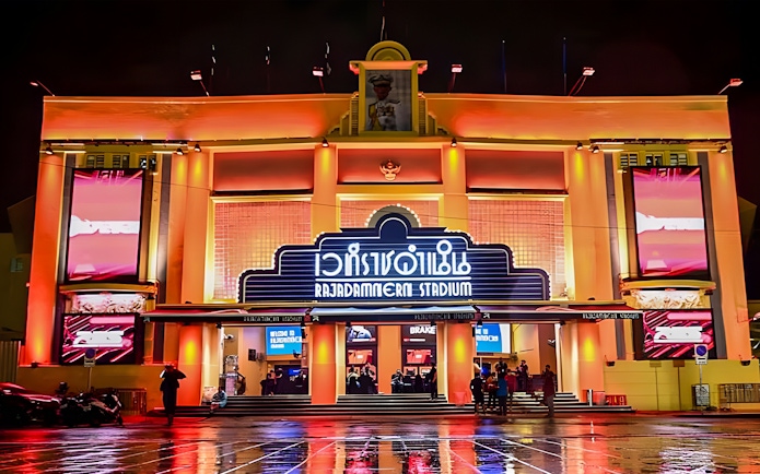 Rajadamnern Boxing Stadium exterior illuminated at night, Bangkok, Thailand.