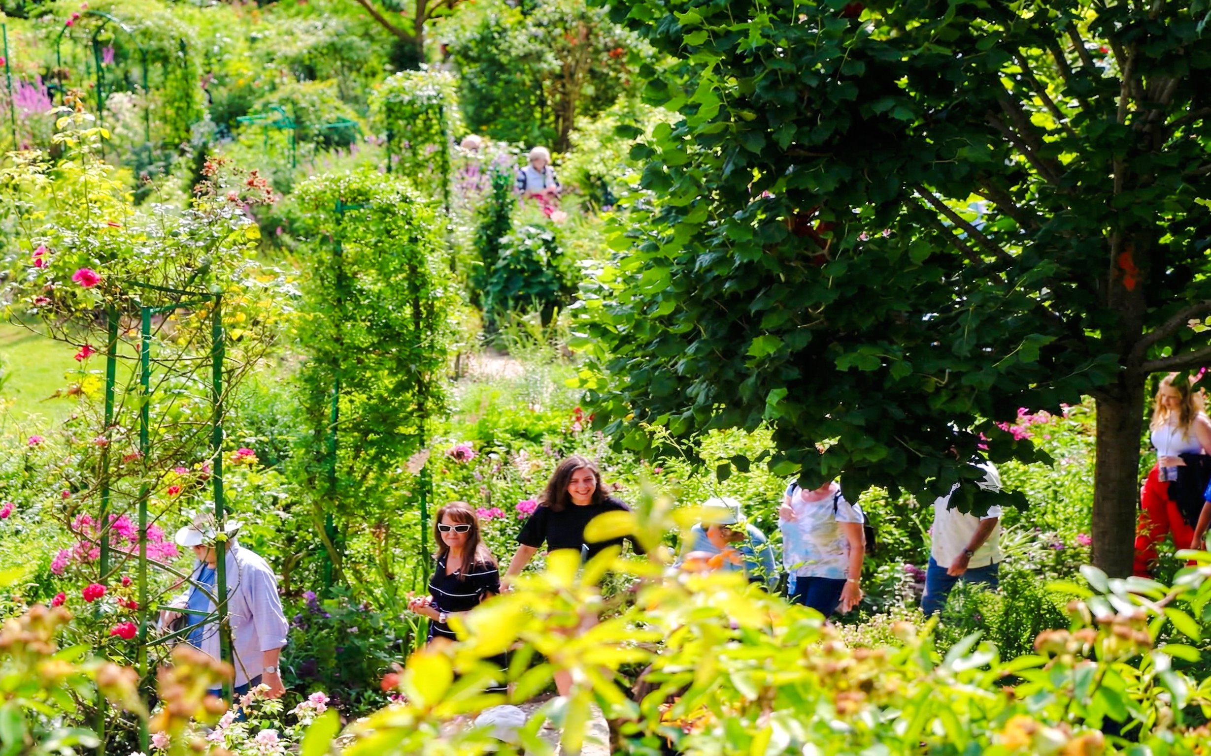 Visitors exploring lush gardens at Claude Monet’s home in Giverny.