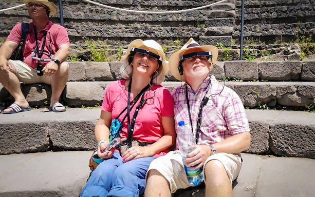 Visitors enjoying augmented reality tour at Pompeii ruins.