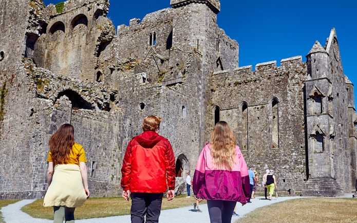 Tourists walking towards Blarney Castle in Ireland.