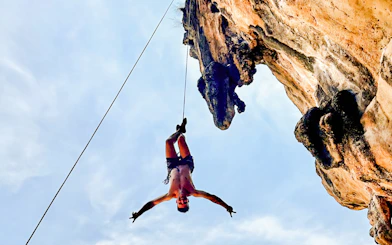 Climber suspended on a rope at Krabi Rock Climbing Courses, Railay, Thailand.