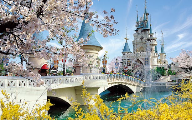 Lotte World castle with cherry blossoms and bridge in Seoul, South Korea.
