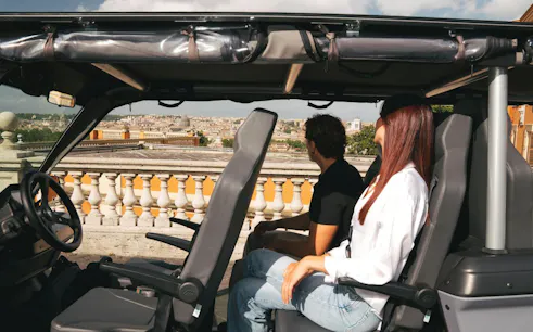 Tourists enjoying a panoramic view of Rome from a golf cart.