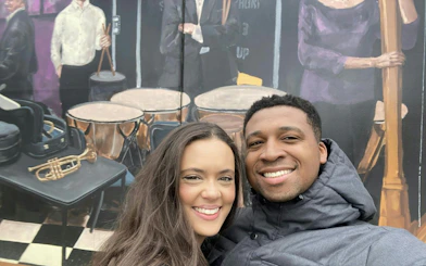 Couple smiling in front of a mural with musical instruments in downtown Atlanta.