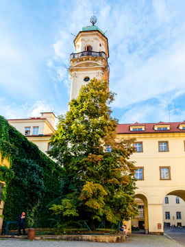Klementinum courtyard with historic tower and ivy-covered walls in Prague.