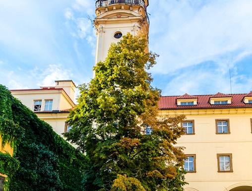 Klementinum courtyard with historic tower and ivy-covered walls in Prague.