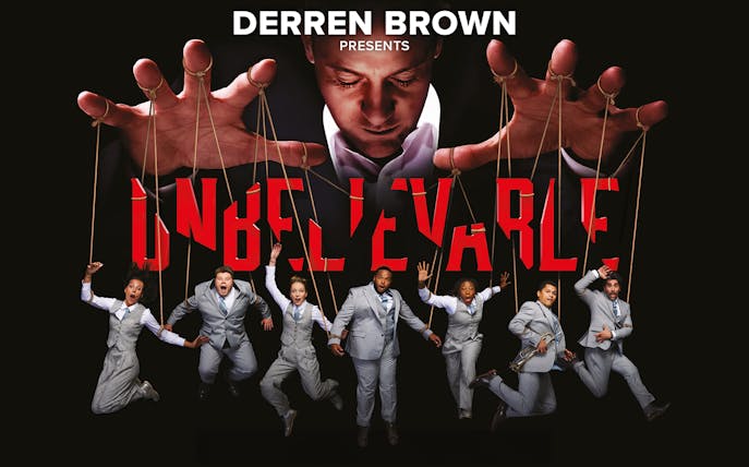 Illusionist controlling performers with strings in "Unbelievable" show.