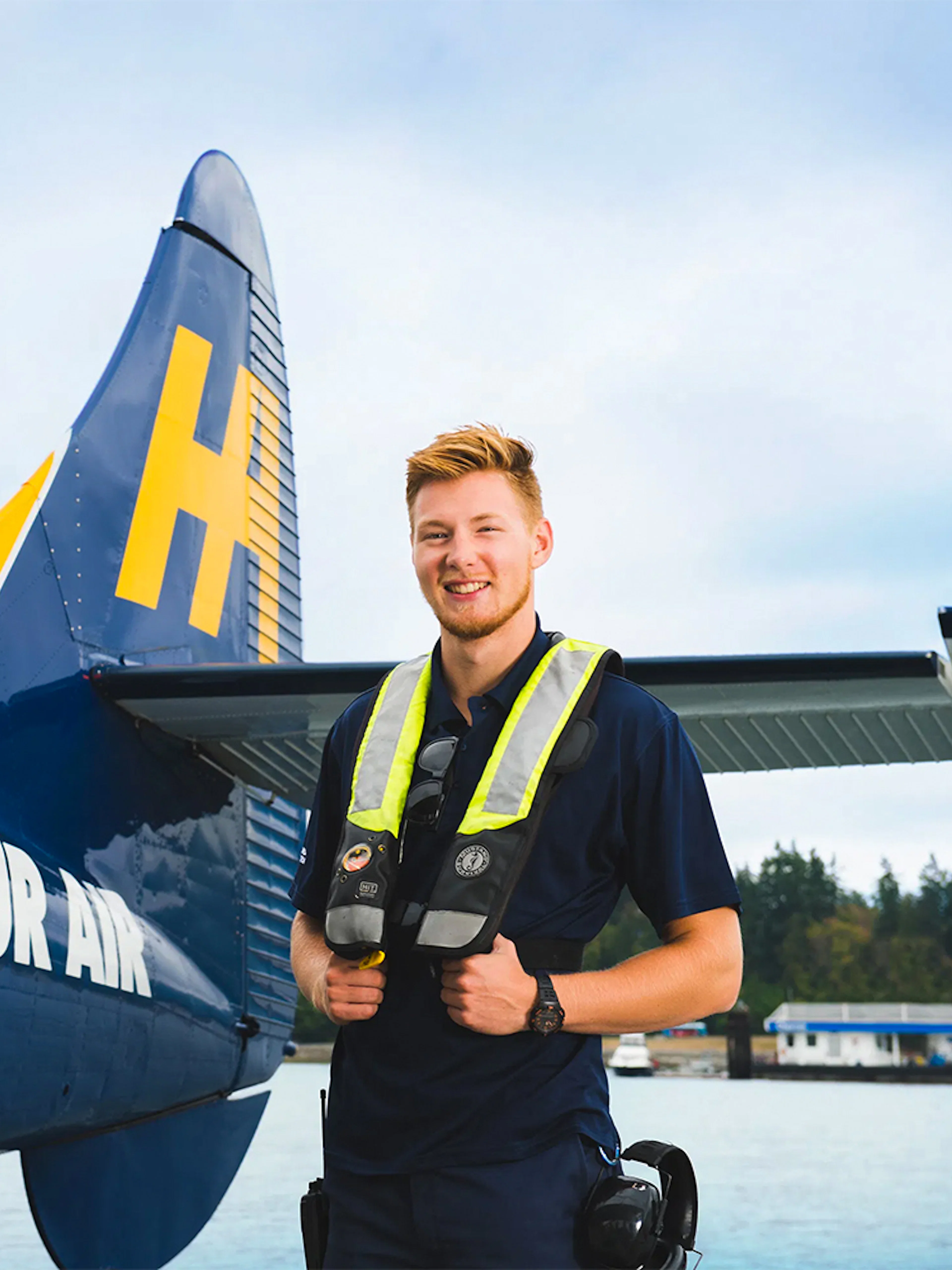 Passenger in safety vest beside seaplane for Scenic Panorama Tour, Vancouver.