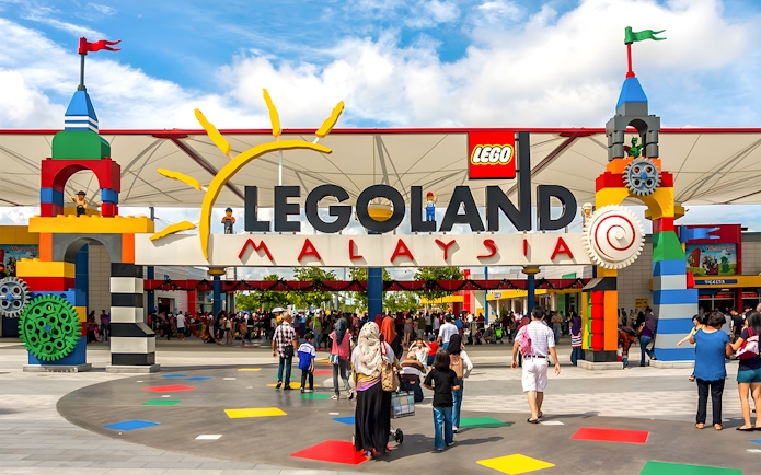 Entrance to LEGOLAND Malaysia with colorful LEGO structures and visitors.