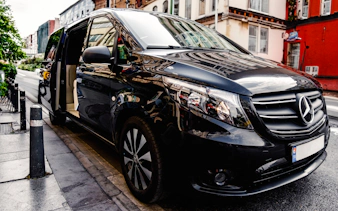 Black van for Zanzibar private transfers parked on a city street.