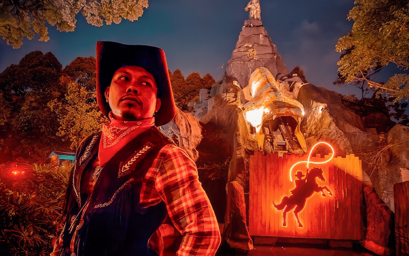 Park employee in cowboy attire at The Good The Bad and The Wild attraction.