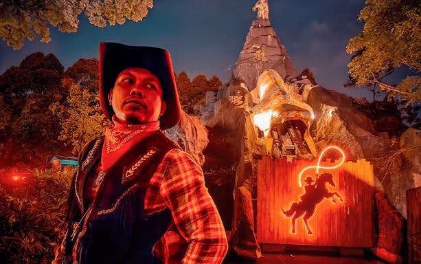Park employee at The Good The Bad and The Wild, Sunway Lagoon, Kuala Lumpur, guiding visitors at night.