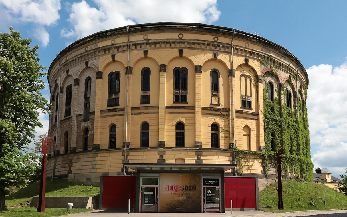 Panometer Dresden entrance with historic cylindrical building and greenery.