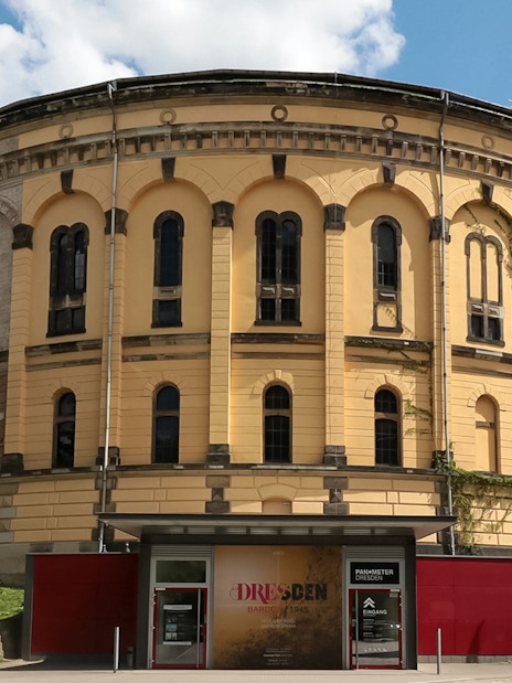 Panometer Dresden entrance with historic cylindrical building and greenery.