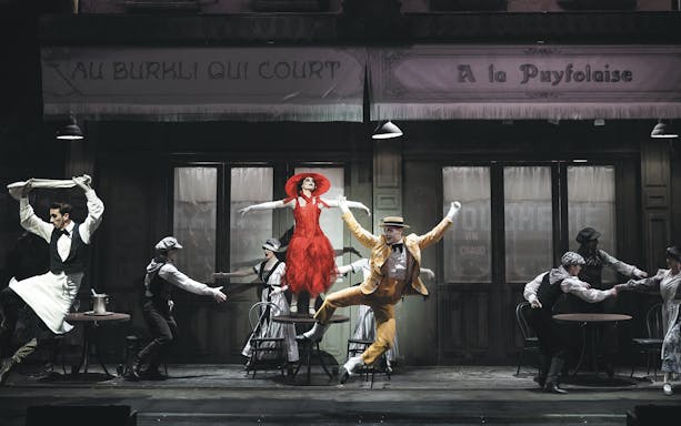 Performers in vibrant costumes dancing at a Puy Du Fou show, France.