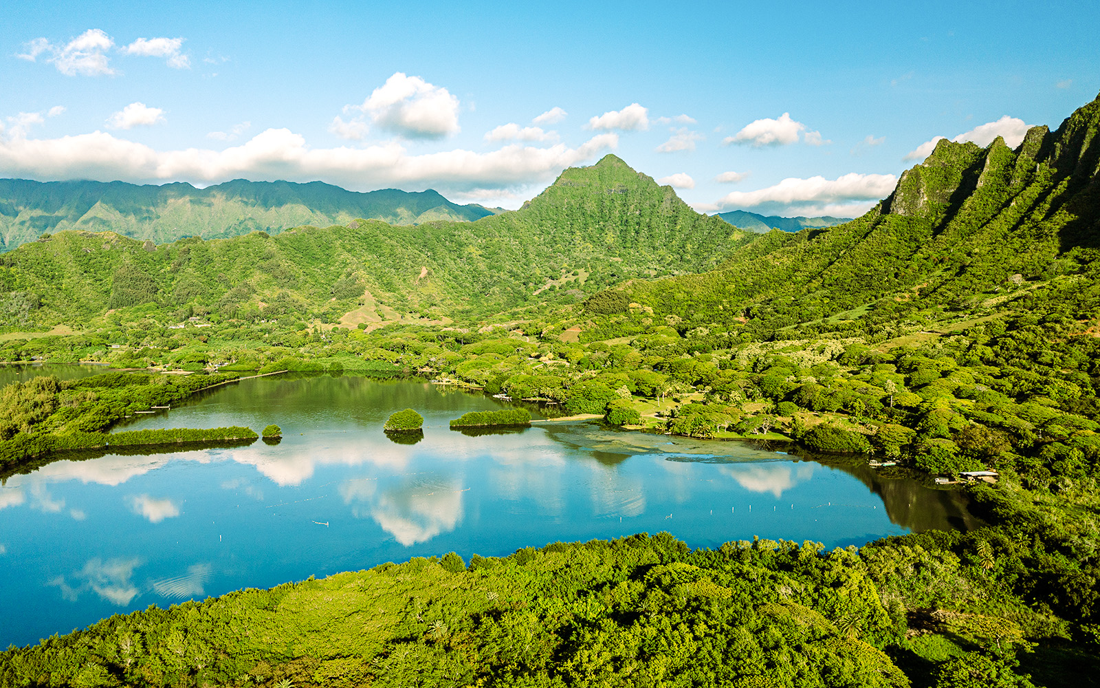 Aerial view of Moli'i fishponds with mountain reflections in Hawaii.