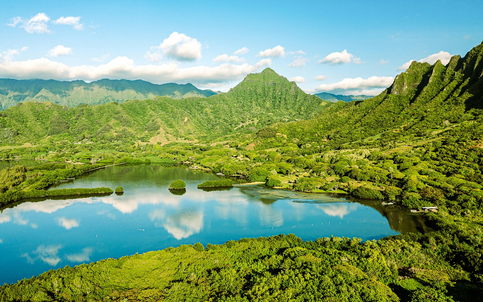 Aerial view of Moli'i fishponds with mountain reflections in Hawaii.