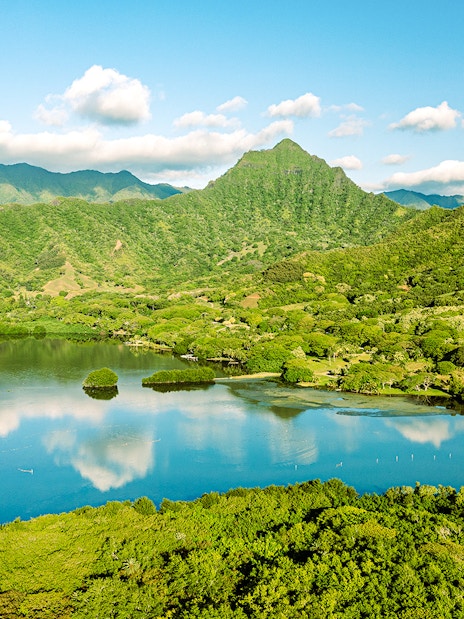 Aerial view of Moli'i fishponds with mountain reflections in Hawaii.