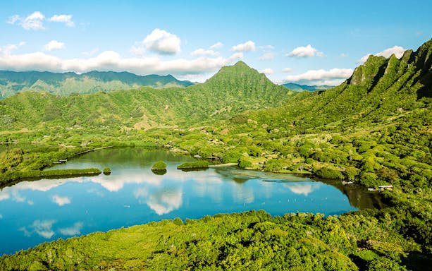 Aerial view of Moli'i fishponds with mountain reflections in Hawaii.