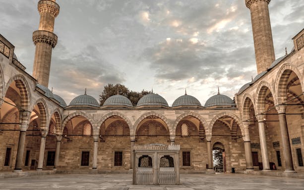 Suleymaniye Mosque courtyard with arches and domes during guided tour in Istanbul.
