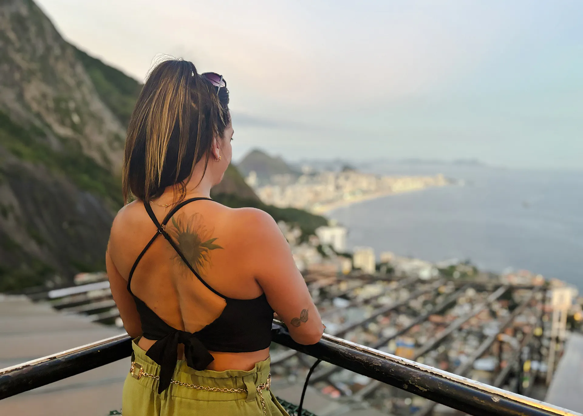 Person enjoying panoramic view of Rio de Janeiro from Vidigal, overlooking cityscape and coastline.