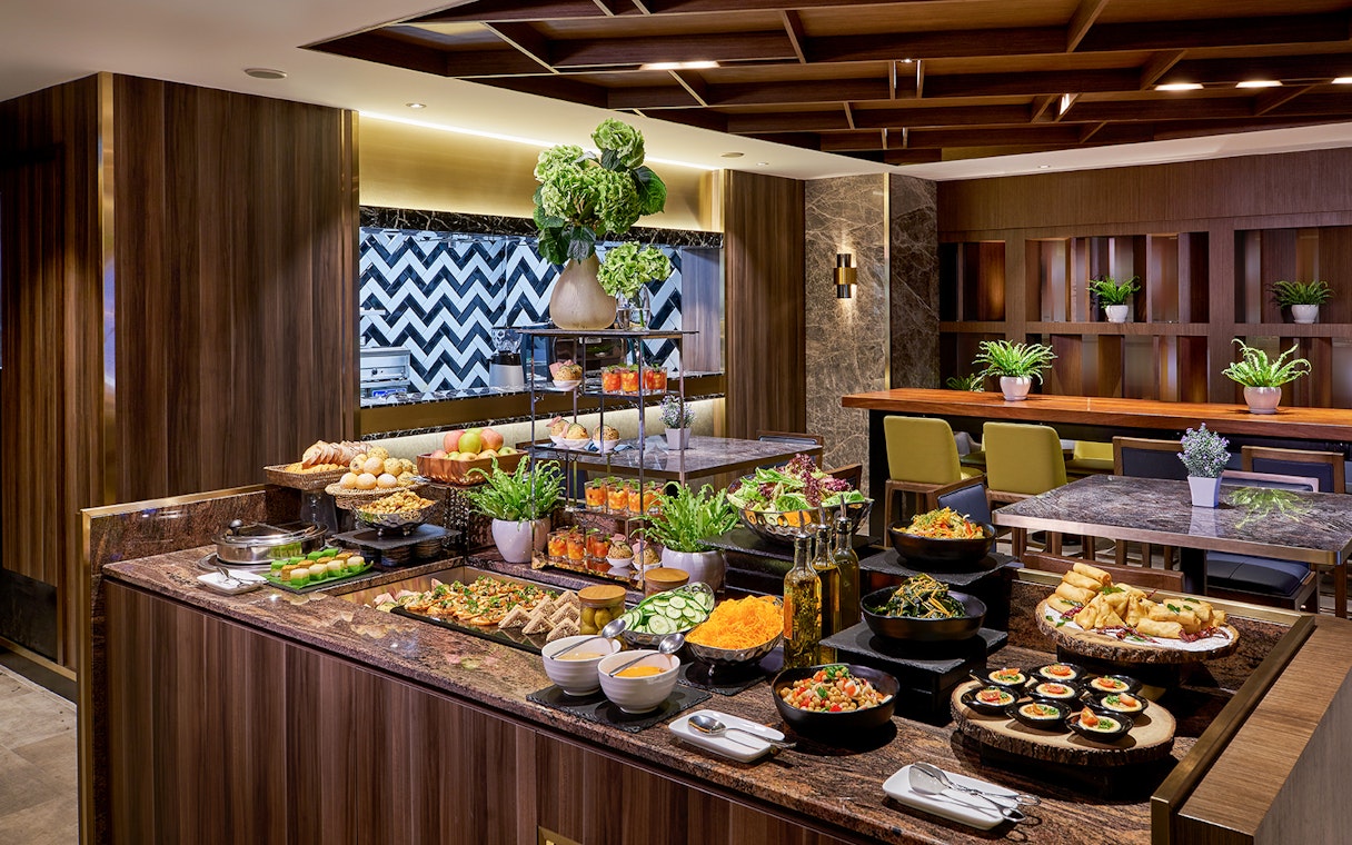 Buffet spread at Plaza Premium Lounge, Penang International Airport, featuring salads, pastries, and beverages.
