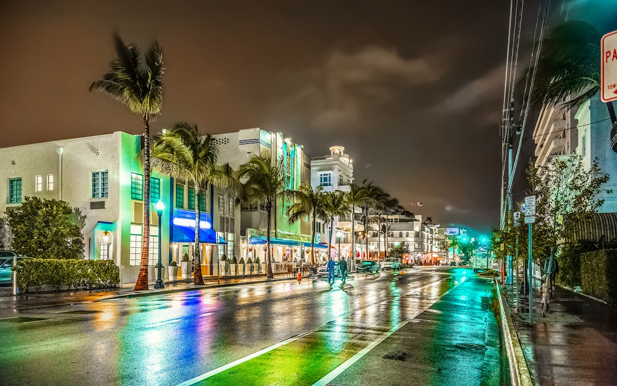 Miami's Ocean Drive at night with neon lights and art deco buildings.