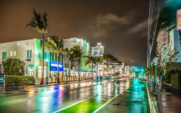 Miami's Ocean Drive at night with neon lights and art deco buildings.