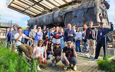 Tour group at bullet-riddled steam locomotive, Korean War relic, DMZ, South Korea.