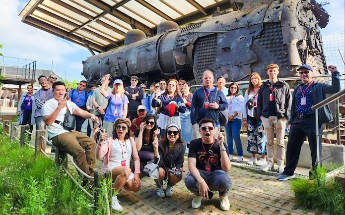 Tour group at bullet-riddled steam locomotive, Korean War relic, DMZ, South Korea.