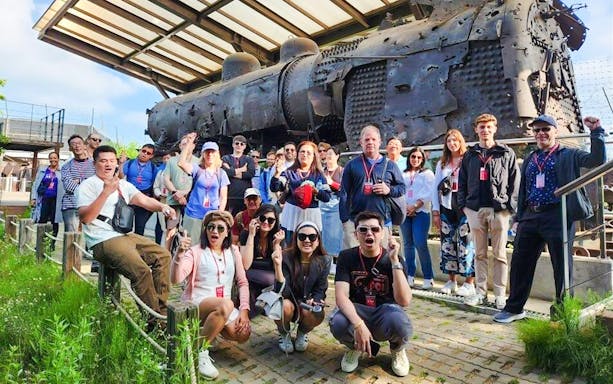 Tour group at bullet-riddled steam locomotive, Korean War relic, DMZ, South Korea.