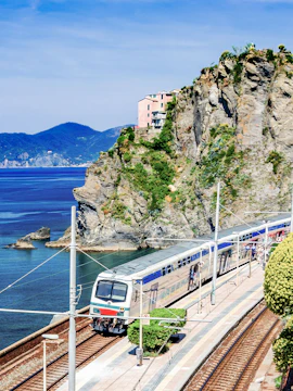 Train passing through coastal cliffs in Cinque Terre, Italy.