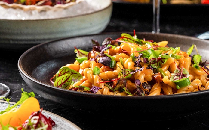 Pasta dish with greens served at CÉ LA VI Dubai with Burj Khalifa views.