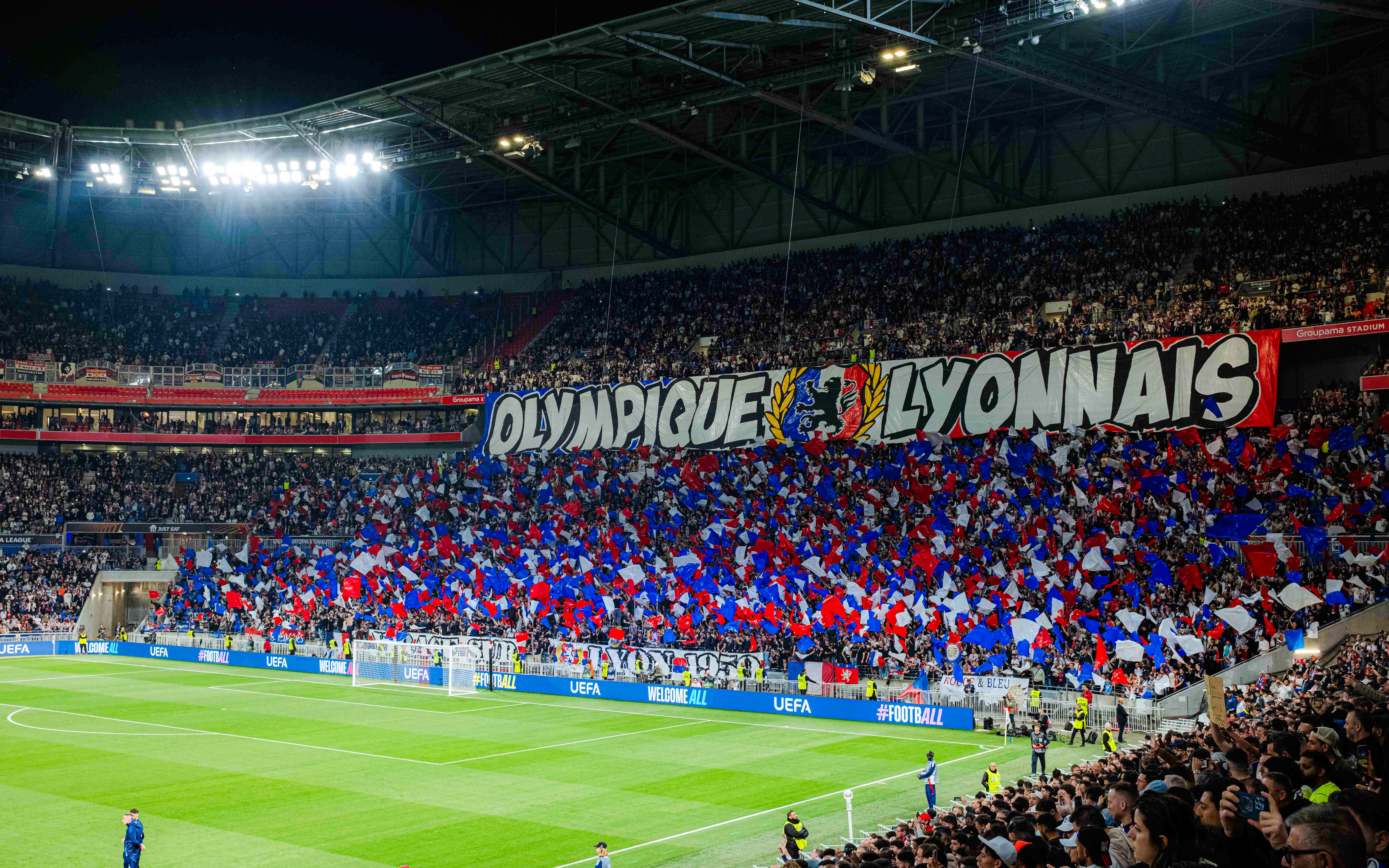 Crowd with flags at Olympique Lyonnais stadium, Lyon, France during a football match.