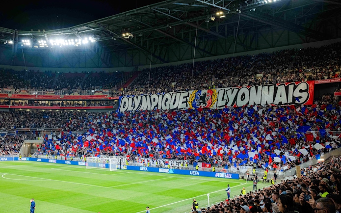 Crowd with flags at Olympique Lyonnais stadium, Lyon, France during a football match.