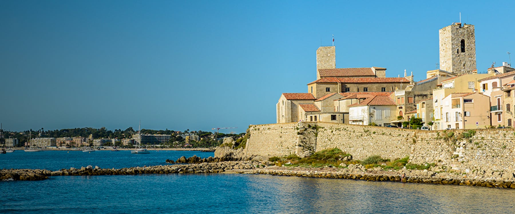Old town of Antibes with stone buildings and towers by the Mediterranean Sea, France.