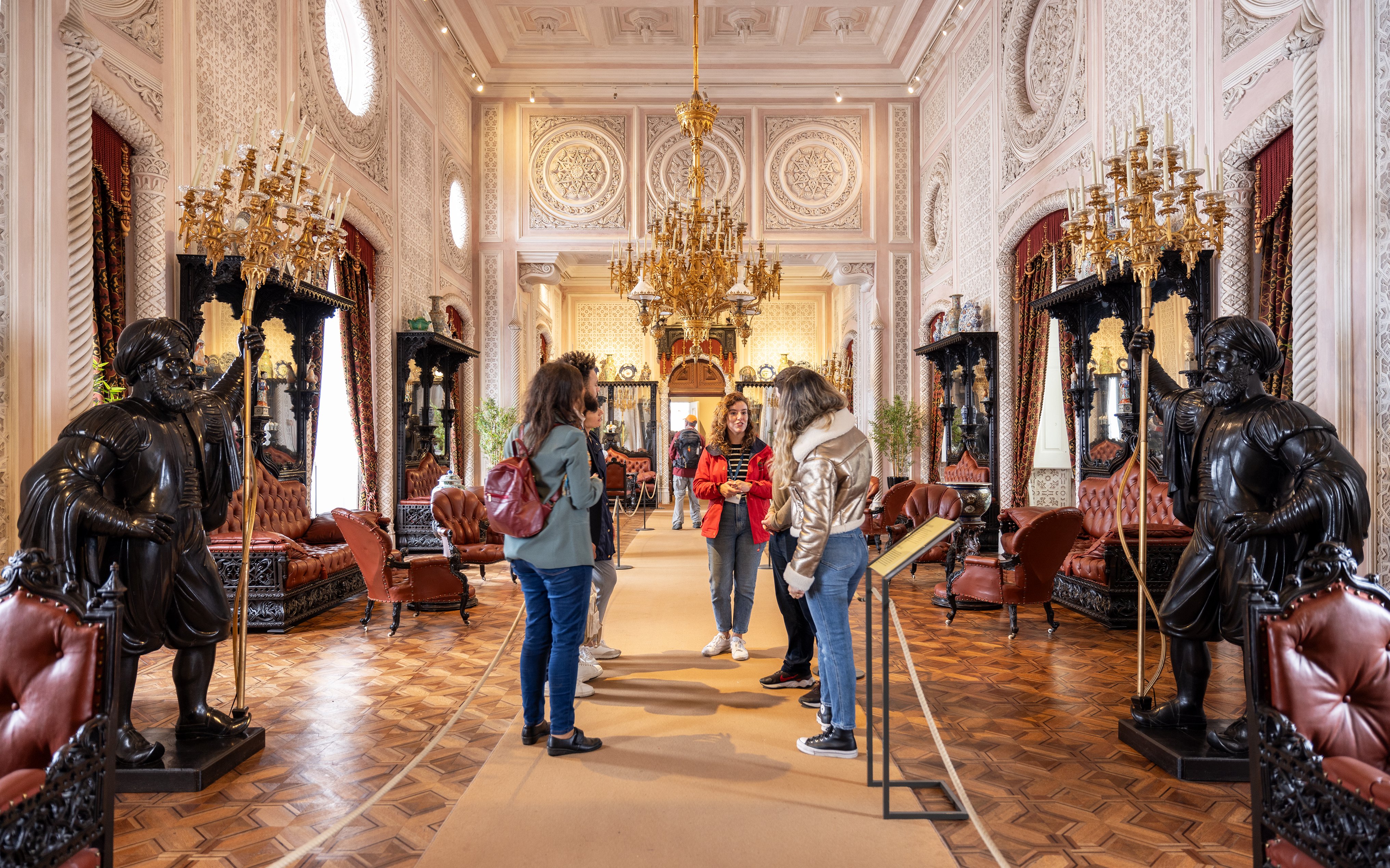 Tourist group with guide in the ornate hall of Pena Palace, Sintra, Portugal.