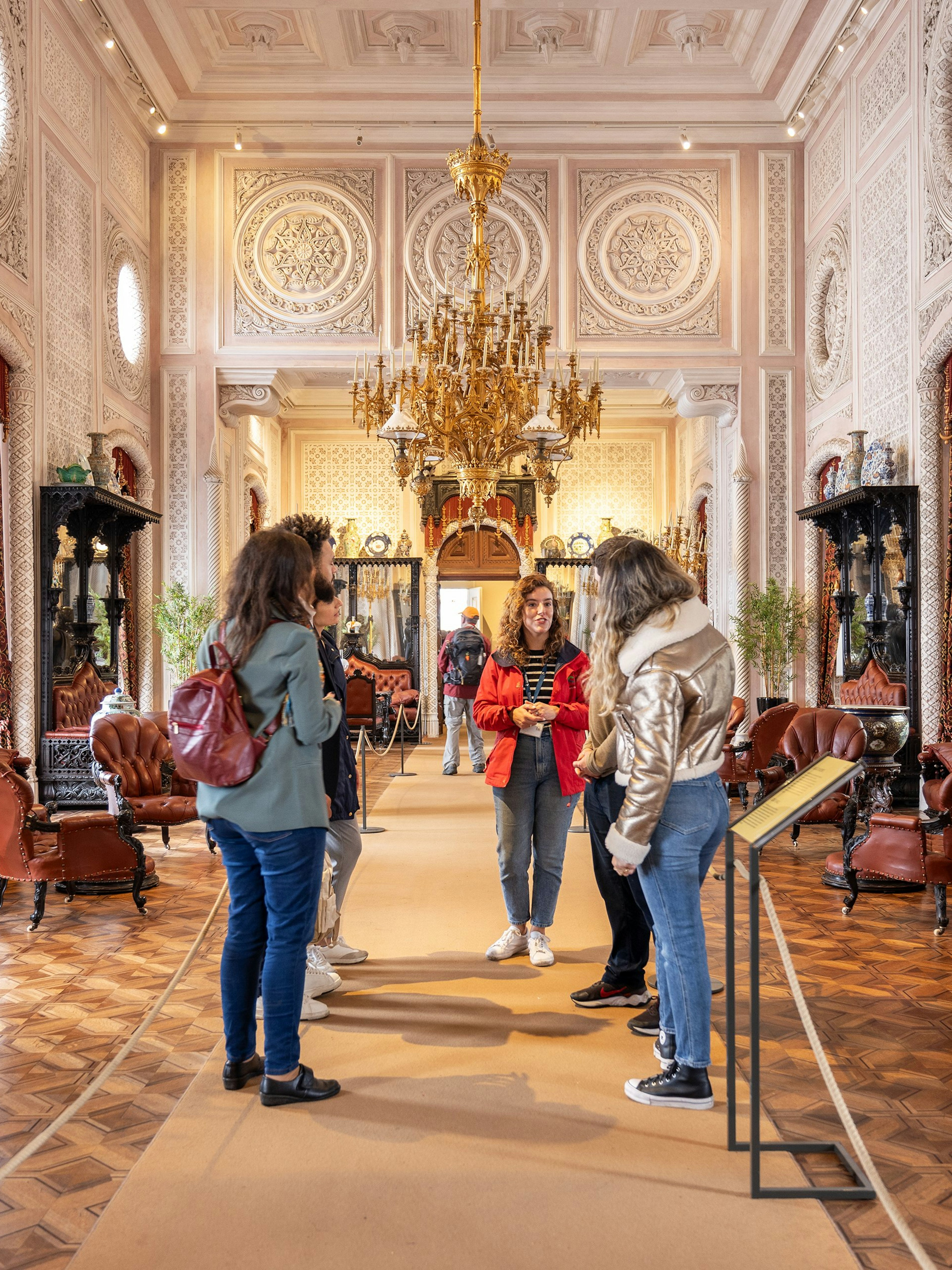 Tourist group with guide in the ornate hall of Pena Palace, Sintra, Portugal.