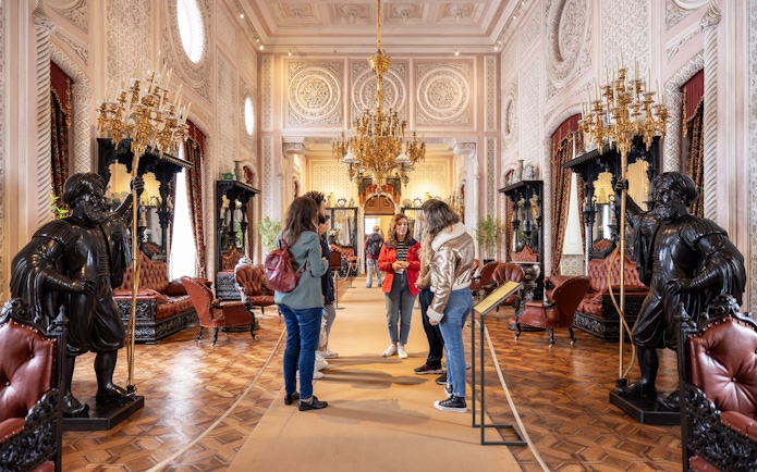 Tourist group with guide in the ornate hall of Pena Palace, Sintra, Portugal.