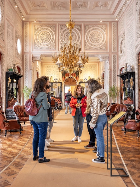Tourist group with guide in the ornate hall of Pena Palace, Sintra, Portugal.