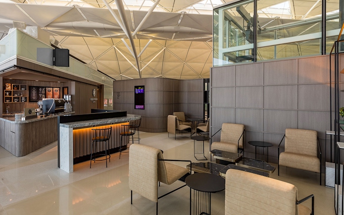 Plaza Premium Lounge seating area with modern decor and coffee bar.