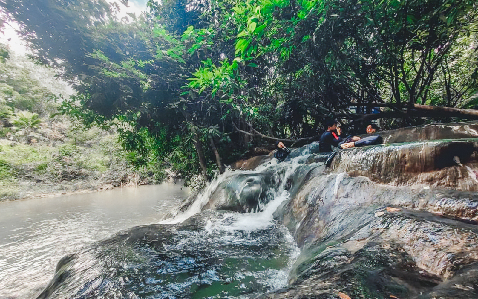 Waterfall surrounded by lush greenery near Tiger Cave Temple, Krabi, Thailand.