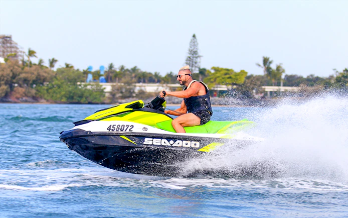 Person riding a jet ski on open water during a Jet Ski & Parasail Experience.