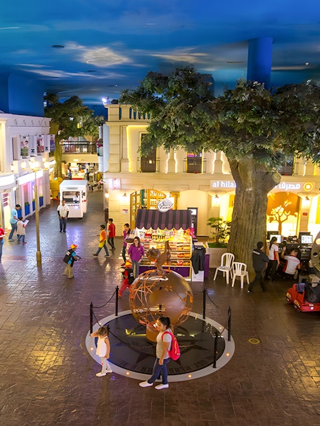 KidZania Abu Dhabi streets with children exploring interactive shops and activities.