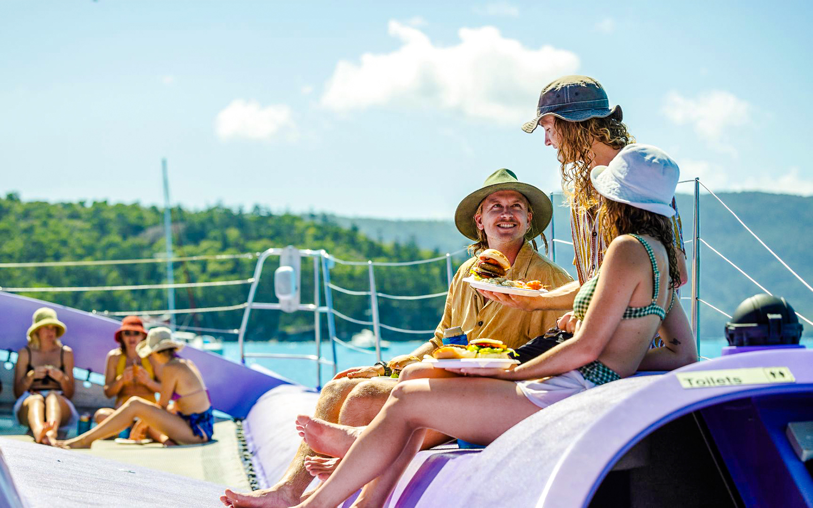 Sailing cruise guests enjoying BBQ lunch on deck, Whitsundays.