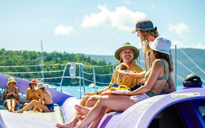 Sailing cruise guests enjoying BBQ lunch on deck, Whitsundays.