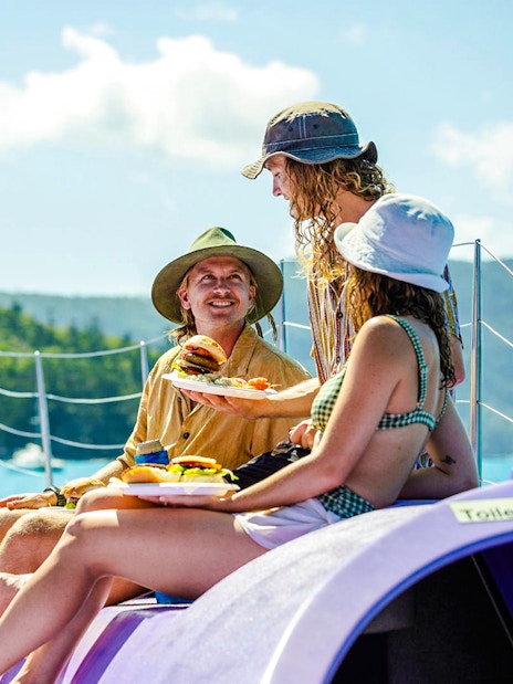 Sailing cruise guests enjoying BBQ lunch on deck, Whitsundays.