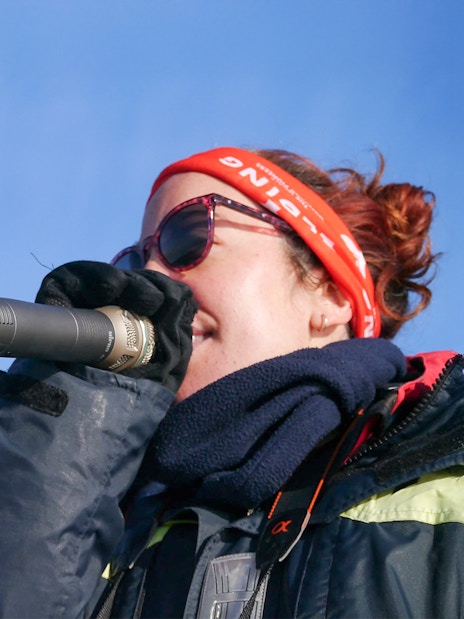 Whale watching guide explaining marine life to guests on a boat in Reykjavik.