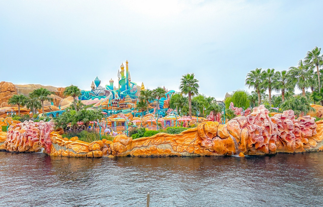 Tokyo Disneyland castle with visitors holding tickets in front.